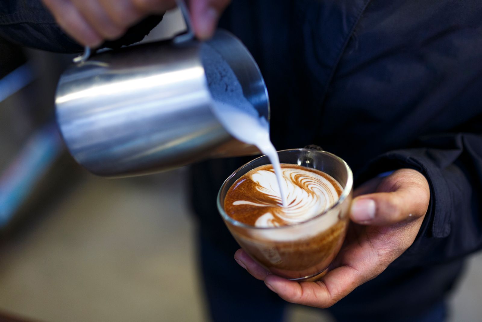 Barista pouring steamed milk
