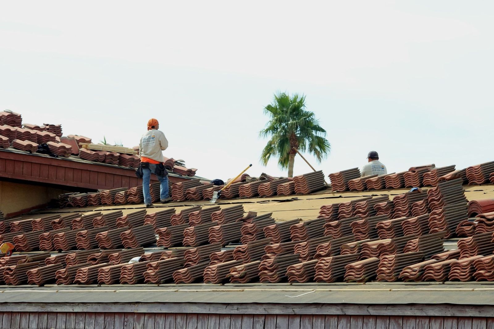 Workers laying terracotta roof tiles
